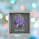 Collar Con Colgante Mariposa Rustica Púrpura Personalizada<br><div class="desc">Crea un regalo único para ella con un collar personalizado de mariposa rústica púrpura plateado. El diseño de un collares presenta una mariposa contra una vid de hojas blancas y un fondo de madera gris oscura con un lugar para personalizar con tu nombre. También hay artículos adicionales disponibles con este...</div>