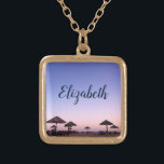 Collar Dorado Purple Sunset California Beach Photo Monograma<br><div class="desc">Una puesta de sol azul violeta y rosa en una playa del sur de California con palapas de paja rebosa de relajación y reflexión. Viaje de vuelta a sus días de playa de vacaciones siempre que use este impresionante y hermoso collar de encanto de nombre personalizado. Este collar se presenta...</div>