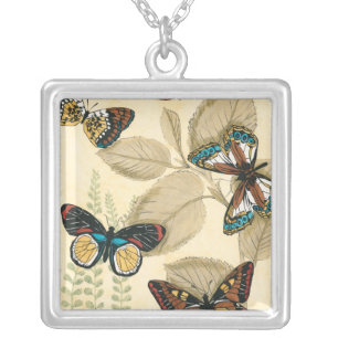 Collar Plateado Mariposas brillando sobre hojas