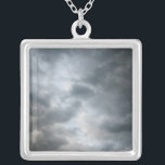 Collar Plateado Rompiendo nubes de tormenta<br><div class="desc">Las nubes turbulentas oscuras se están rompiendo en el primer plano de esta fotografía de color. Las capas de nubes se vuelven tonos más claros de gris más profundo en la imagen. Se ven indicios de cielo azul claro más allá de las nubes de tormenta cuando el tiempo empieza a...</div>