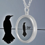 Collar Plateado Silhouette de Black Raven con Iniciales<br><div class="desc">Un solitario Raven encaramado en un alambre de silueta negra contra un cielo gris en este collar gótico-pendante. A lo largo de la historia y las culturas del mundo, el cuervo se encuentra en la tradición, la mitología y la literatura. El simbolismo del cuervo es variado. Es genial para los...</div>