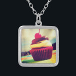 Collar Plateado Torta colorida con cereza en la parte superior<br><div class="desc">Una brillante foto de verano de un delicioso quequito. Esta imagen tiene nubes esponjosas blancas y montañas en el fondo. El delicioso quequito está contenido en una envoltura rosa brillante y roja violeta. El quequito en sí es una combinación de tarta de vainilla y chocolate con una cereza jugosa encima...</div>