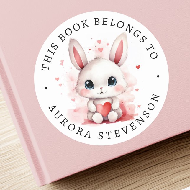 Conejito lindo sosteniendo la etiqueta del libro d (Cute bunny holding heart library book label)