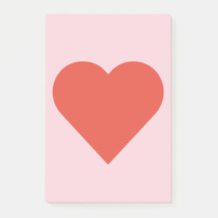 Corazón rojo en nota de post-it rosada del fondo