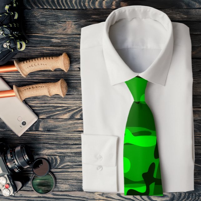 Corbata de camuflaje de verde neón a verde oscuro (Lime green camo necktie is featured on an assemblage of outdoor accessories.)