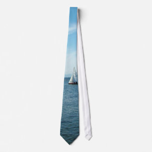 Corbata mar y barco de vela bajo cielo azul