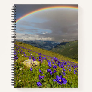 Cuaderno Arcoiris sobre un prado florido
