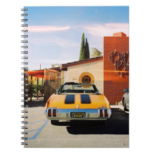 Cuaderno Auto azul estacionado al lado de un edificio de ho