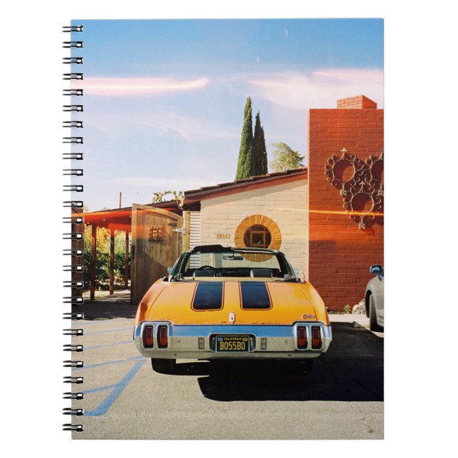 Cuaderno Auto azul estacionado al lado de un edificio de ho (Frente)