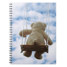 Cuaderno Beertje op schommel met bewolkte blauwe lucht.