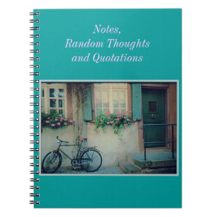 CUADERNO BICICLETA CONTRA EDIFICIO VIEJO CON CAJAS DE FLORE