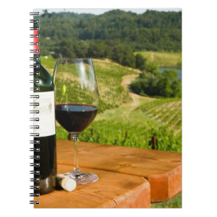 Cuaderno Botella de vino rojo y de vidrio en la tabla