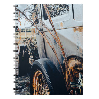Cuaderno con fotografía de auto antiguo abandonado