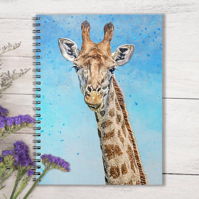 Cuaderno Curiosa jirafa con cielo azul de confetti (Sky Blue Notebook with Smiling Giraffe on Tabletop with purple flowers)