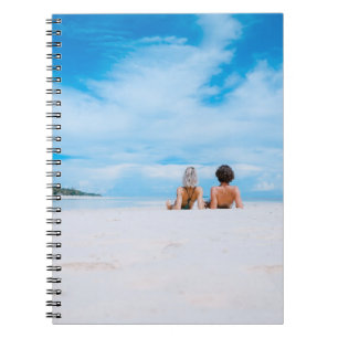 Cuaderno Dos mujeres tumbadas en una playa de arena blanca