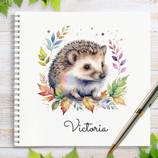 Cuaderno Erizo de Acuarela Animal del Bosque Personalizado (A spiral-bound notebook with cover illustration of a hedgehog and leaves in a watercolor style)