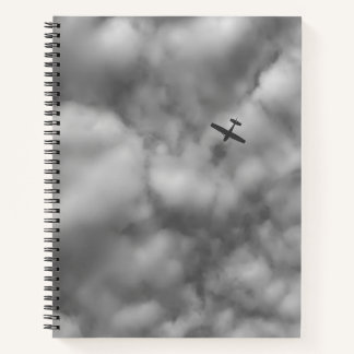 Cuaderno Foto de pequeño avión volando en un cielo nublado