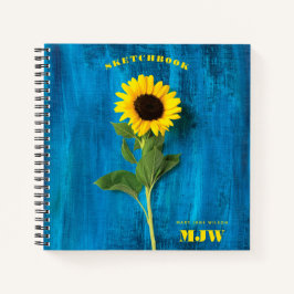 Cuaderno Girasol vibrante y monograma sobre fondo azul