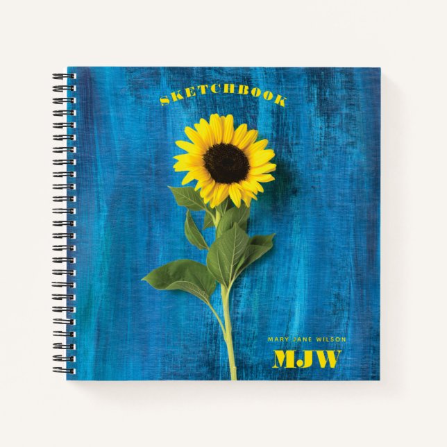 Cuaderno Girasol vibrante y monograma sobre fondo azul (Anverso)