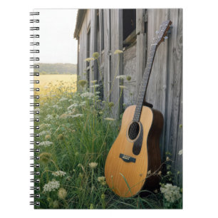 Cuaderno Guitarra acústica apoyada en un granero rural