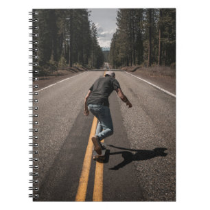 Cuaderno Hombre jugando al patinaje en la carretera por la