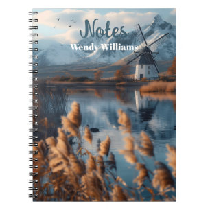 Cuaderno Molino de viento en un lago con paisaje montañoso