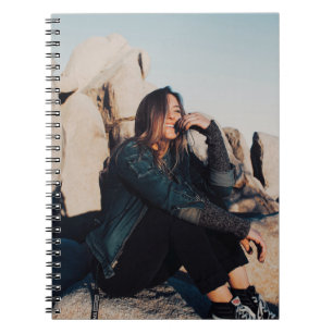 Cuaderno Mujer sentada y sonriente con pantalones negros