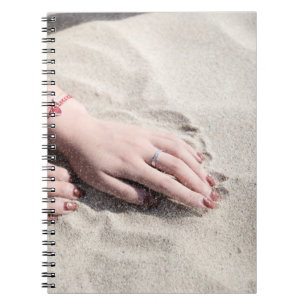 Cuaderno Mujer tendida sobre arena blanca