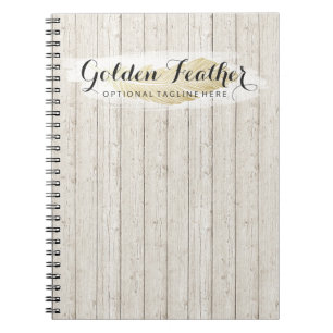 Cuaderno Pluma bohemia dorada sobre tablas de madera rústic