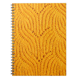 Cuaderno Suéter de punto naranja, fondo texturado.