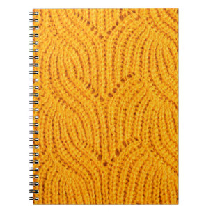 Cuaderno Suéter de punto naranja, fondo texturado.