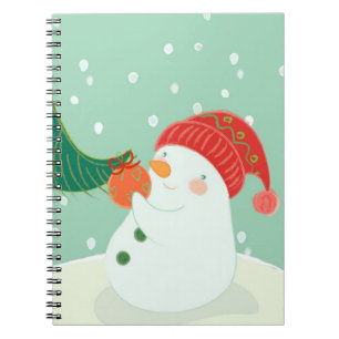 Cuaderno Un muñeco de nieve que cuelga un ornamento en un