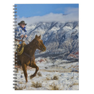 Cuaderno Vaquero a caballo que lleva chaparreras de cuero