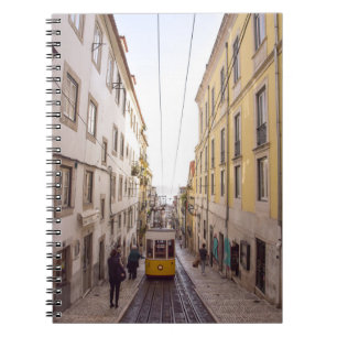 CUADERNO VEHÍCULO AMARILLO Y GRIS PASANDO POR LA CARRETERA
