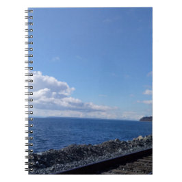 Cuaderno vía marítima y de tren bajo cielo azul