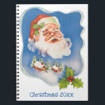 Cuaderno Vintage Christmas, Retro Jolly Santa Claus<br><div class="desc">Diseño de vacaciones de Navidades de ilustracion de época con un Santa Claus flotante frente a un pueblo cubierto de nieve. Cinta con estrellas y Navidades enmarcan la escena.</div>