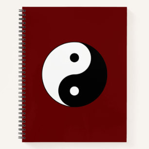 Cuaderno Yin Yang blanco y negro sobre fondo rojo rubí
