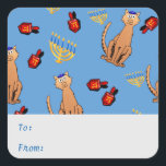 Cuadrada Hanukkah Cat Dreidel Blue Gift Pegatina<br><div class="desc">Los amantes de los gatos estarán encantados con este divertido y caprichoso pegatina de etiquetas de regalo "Hanukkat", que presenta un naranja gato pardo curioso vestido con un kippa, dreidels rojos y menorahs/channukiahs amarillos sobre un brillante fondo azul. Perfecto para envolver tus regalos Hannukah / Chanukah durante el Festival de...</div>