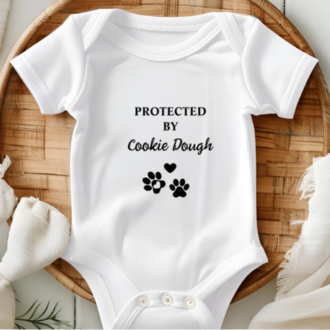 Cuta personalizada protegida por perro (Adorable baby bodysuit with "Protected by (Dog's Name)" design, featuring hearts and paw prints.)