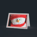 Cuta tarjeta de Navidades de Snowman<br><div class="desc">Este es un acercamiento de una cara adorable sobre un hombre de nieve material. Ha cruzado los ojos y una gran sonrisa,  un gorra de cuchillos rojos,  guantes y una nariz de zanahoria.</div>