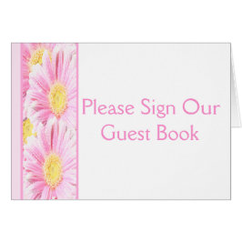 Daisies de Gerbera rosada en tarjeta de mesa blanc