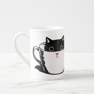 De Porcelana Gatito negro con nariz roja escondido en una taza