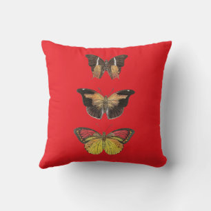 Decorativo Tres mariposas rojas y doradas sobre cojín rojo