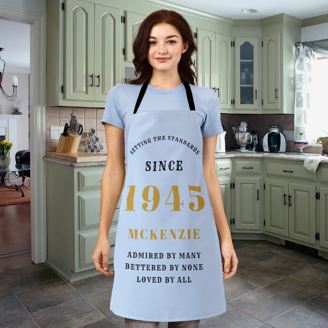 Delantal 80.º cumpleaños 1945 Moda de nombre elegante oro a (Personalized 80th birthday long apron in light blue with black and gold print.)