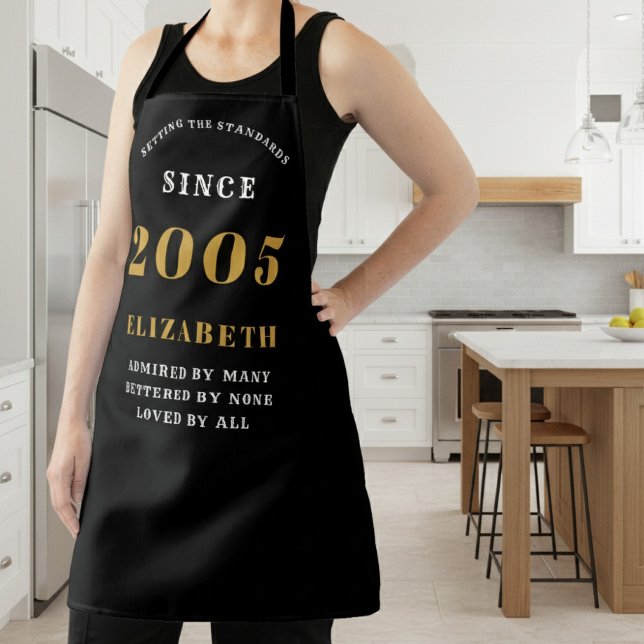 Delantal Cumpleaños 21 personalizado 2005 negro y dorado (2005 birthday apron worn in the kitchen)