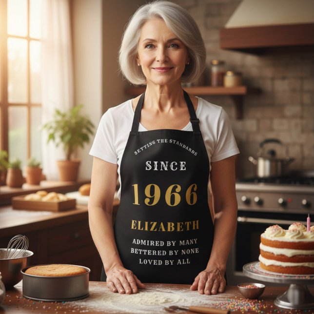 Delantal Cumpleaños 60 Personalizado 1966 Negro y Dorado (1966 birthday apron. Black and gold worn in a kitchen)
