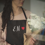 Delantal Monograma Guión manuscrito del corazón rojo negro<br><div class="desc">Un diseño de monograma minimalista con grandes iniciales tipográficas en un tipo de letra de guión con un corazón rojo sobre un simple fondo negro. ¡El regalo o accesorio perfectamente personalizado!</div>