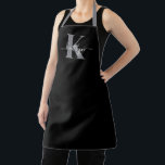 Delantal Monograma moderno de guión gris negro<br><div class="desc">Este sencillo y elegante delantal negro con tu nombre en una fuente de escritura a la moda en blanco tecleado sobre tu primera inicial en un moderno tipo de letra de tope en gris es perfecto para cuando cocinas,  entretenidas,  barbacoas. Es de diseño y a la vez muy clásico.</div>