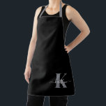 Delantal Monograma moderno de guión gris negro<br><div class="desc">Este sencillo y elegante delantal negro con tu nombre en una fuente de escritura a la moda en blanco tecleado sobre tu primera inicial en un moderno tipo de letra de tope en gris es perfecto para cuando cocinas,  entretenidas,  barbacoas. Es de diseño y a la vez muy clásico.</div>