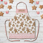 Delantal Navidades rosados, creadores de cocina<br><div class="desc">Un lindo patrón de galletas de jengibre navideño decora este delantal de la tripulación de galletas de los Navidades. Personalízalo con tu nombre. ¡Tan divertido para los Navidades horneando! El borde del delantal tiene un patrón de puntos polka rosados y blancos con rac ric. Hace un regalo divertido para los...</div>